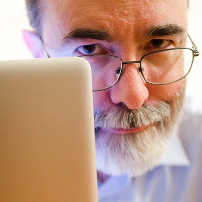 Marty looking out from behind a MacBook